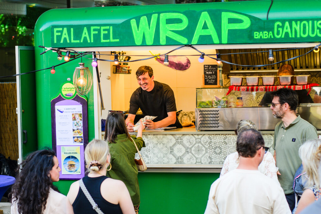 L'Aubergine Food Truck owner serving authentic Mediterranean falafel wraps at a corporate event in Amsterdam, Noord-Holland. 2024 Horeca Prijs winner.